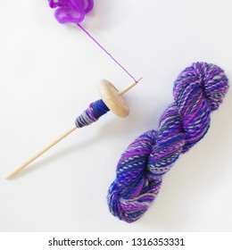 Wooden Drop Spindle With Fiber And Hand Spun Skein Of Yarn - Table Top View