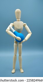 Wooden dummy with small blue enema      - Shutterstock ID 2258249669