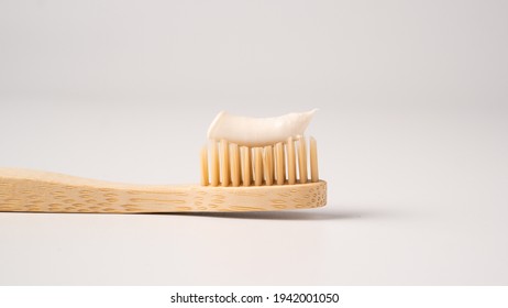 Wooden eco toothbrush with toothpaste on a white background. Bamboo toothbrush.