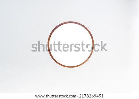 Wooden edged circular mirror on a white background.