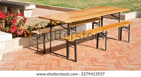 Wooden empty new picnic table with sittings of wood and metal on public park 