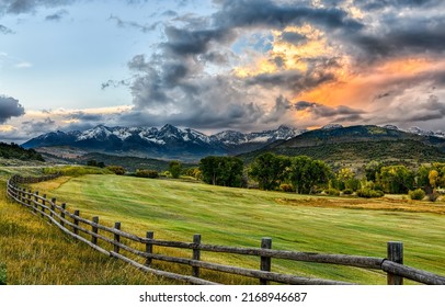 Wooden fence around an pasture field in a mountain valley. Pasture fence. Pasture wooden fence. Fence on pasture