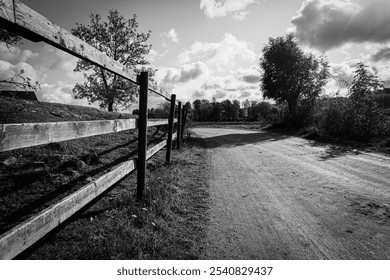 A wooden fence next to a gravel road - Powered by Shutterstock