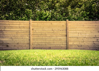 Wooden fence on a green lawn