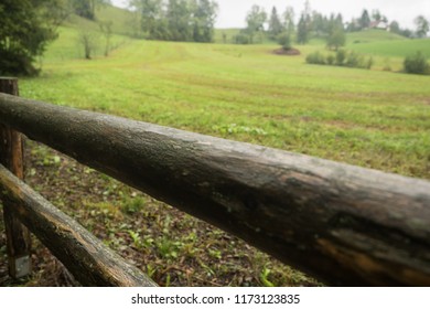 Wooden fence on a green meadow in autumn