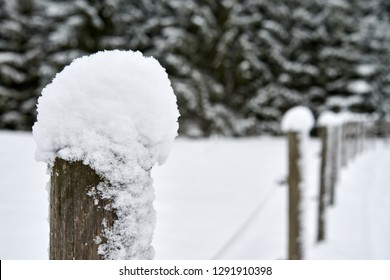 Wooden Fence Pole Snow Covered With Snow.