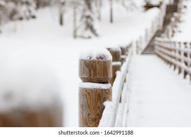 Wooden Fence Post With Snow Cap In Winter In The Park