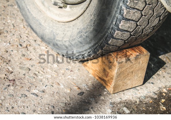 Wooden\
fence under the wheel for the machine. Wheel\
stop