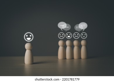 The wooden figure, isolated from the crowd, seemed happy from being chosen over confusion and conflict with others. Leadership concept, dissent, rejection, doubt. Wooden peg doll, wooden puppet. - Shutterstock ID 2201781779