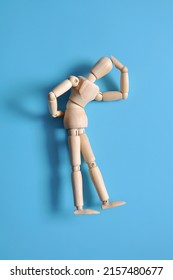 A wooden figure of a man holding his back. Back pain