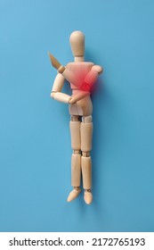 A wooden figure of a man holding his elbow. Elbow pain. Elbow injury