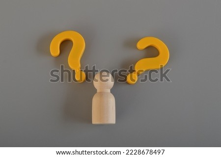 Wooden figure and question mark symbols.