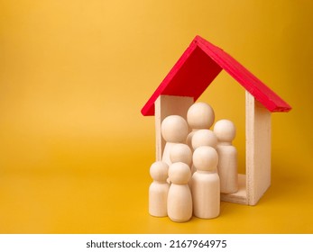 Wooden Figures Inside Wooden House. Concept Of Family And House.