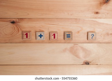 Wooden figures with mathematical tasks on a wooden background. Top view