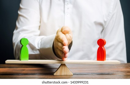 Wooden figures of people on scales and a mediator / arbitrator. Resolving conflict situations and disputes. Conclusions of the peaceful resolution of disputes. Conflict of interest. Business opponents - Shutterstock ID 1433999231