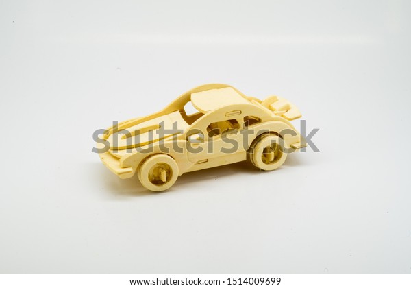 Wooden figurine of a car\
on a white background. Minimalism. The concept of car insurance,\
buying and selling cars. Repair and maintenance of vehicles. A\
wooden toy. banner