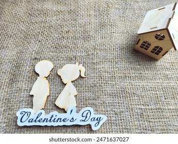 Wooden figurines of a couple, a house and the inscription Valentine's Day. The concept of a holiday of love and lovers. Background, texture, place for text and copy space - Powered by Shutterstock