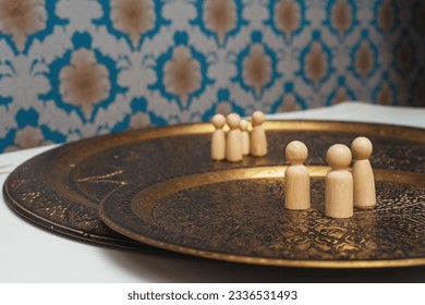 wooden figurines of people on the table. subject photo session of humanoid toys in the room. wooden toys on a bronze plate - Powered by Shutterstock