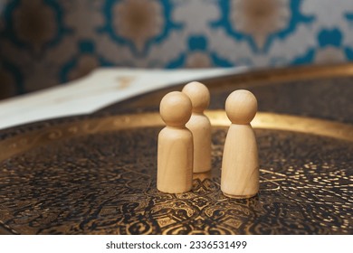 wooden figurines of people on the table. subject photo session of humanoid toys in the room. wooden toys on a bronze plate - Powered by Shutterstock