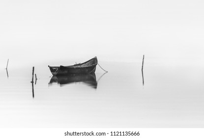 Wooden Fishing Boat On Water.Black And White Photography