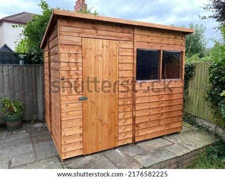 Wooden flat roof shed in garden