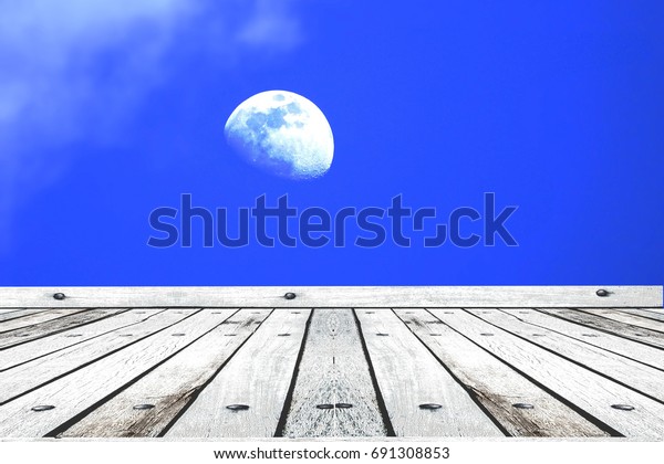 Wooden floor with\
moon on blue sky\
background.