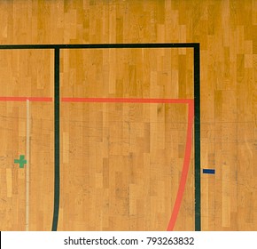Wooden floor in sporting hall with solid and dotted lines.  Light reflection in polished wooden floor with colorful marking lines