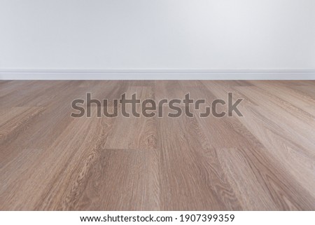 Wooden floor with white wall and floor skirting