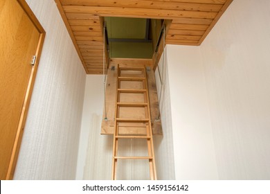Wooden folding ladder to the attic, old empty house close-up