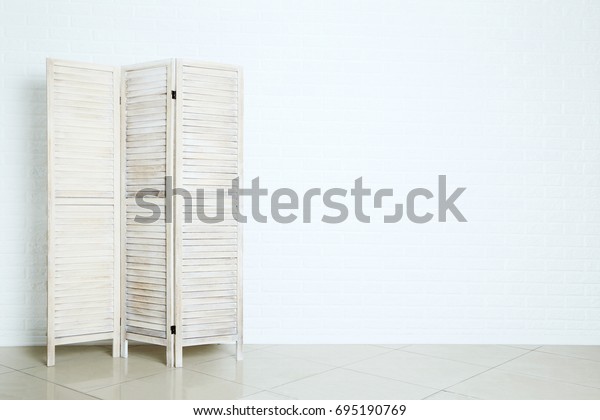 Wooden\
folding screen on the brick wall\
background