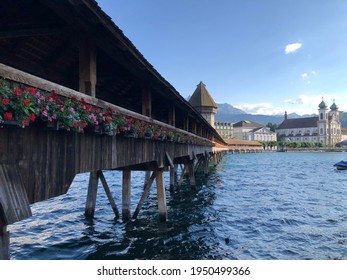 Wooden Footbridge (Kapellbrücke) And Baroque Church In Lucerne, Switzerland