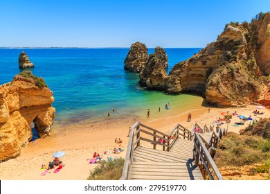 Wooden footbridge to beautiful beach Praia do Camilo, Portugal