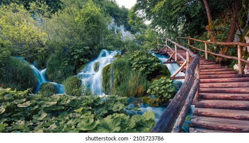 Wooden footbridge in Plitvice National Park. Fresh green scene of summer forest with pure water waterfall. Beautiful countryside landscape of Croatia, Europe. Beauty of nature concept background. - Powered by Shutterstock
