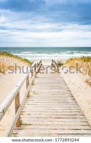 Wooden footpath on dune on Sylt. Entrance for the beach. North Germany.