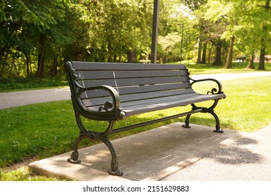A wooden forged bench with metal armrests in a park - Shutterstock ID 2151629883