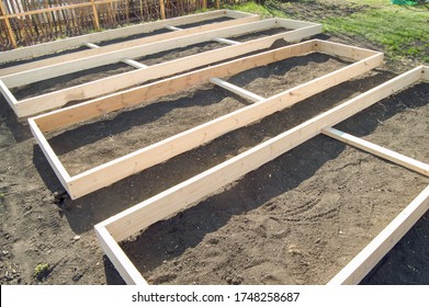 Wooden formwork from new boards for vegetable beds in the garden, preparation and construction, carpentry. - Shutterstock ID 1748258687