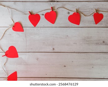 A wooden frame with a red heart pattern is displayed. The frame is empty, and the heart pattern is made up of red hearts. The frame is placed on a wooden surface - Powered by Shutterstock