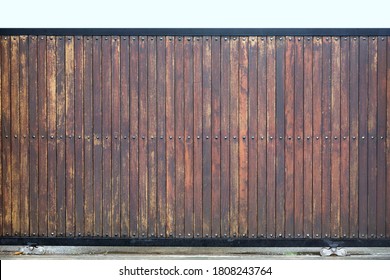 Wooden Garage Door Exterior Of Modern Home Background. Giant Gate Fencing With Wood And Iron Slice With Wheel In Loft Style