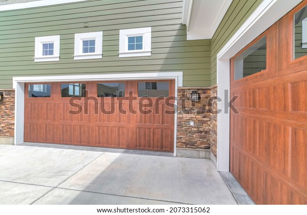 Wooden\
garage doors with window panels and wall\
lamp