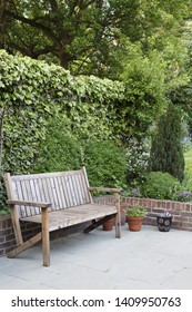 Wooden Garden Bench On A Patio In A Typical Suburban Back Garden In London, UK