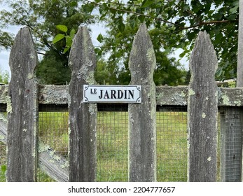 A Wooden Garden Fence Gate With A Sign That Reads 