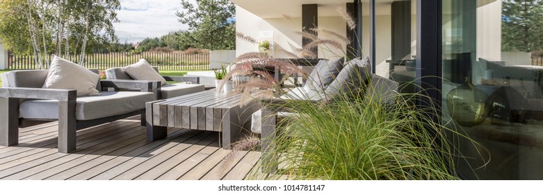 Wooden garden furniture on terrace with a floor constructed of wood boards