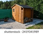 A wooden garden shed standing on a concrete foundation in a garden.