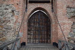 Wooden Gate And Bridge With Ruined Brick Walls Of An Old Stone Castle Close-up