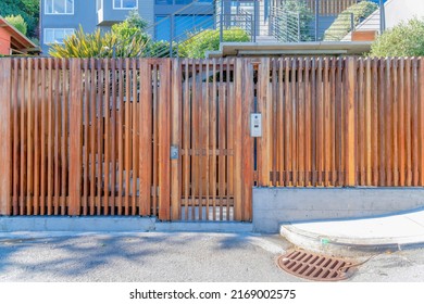 Wooden Gate And Fence Of A Residential Building With Doorbell Camera Intercom In San Francisco, CA. Apartment Gate Entrance With A View Of Entrance Staircase And Decks At The Background.