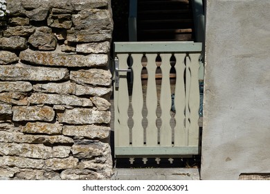 Wooden gate in a stone wall in on the back of the home garden. The gate is closed with a padlock. High quality photo