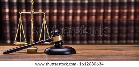 Wooden Gavel With Golden Scale On Table
