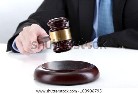 wooden gavel in hand on gray background