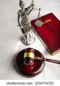 Wooden Gavel Of The Judge, Bronze Figurine Of The Goddess Of Justice Themis And The Holy Bible On A White Background. Low Angle View. There Are No People In The Photo. Court. Justice.