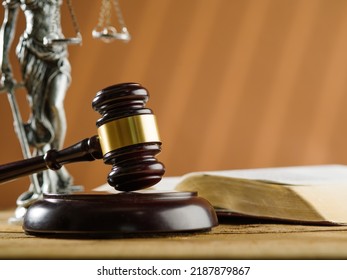 Wooden Gavel Of A Judge, An Open Book And A Bronze Figurine Of Themis On A Beige Background. Symbols Of A Fair And Honest Trial. Constitution, Bible, Rule Of Law, Patriotism.